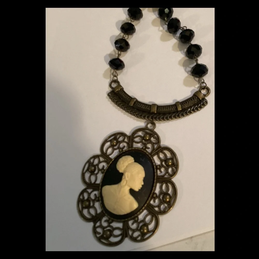 Black and cream vintage necklace on a bronze chain.